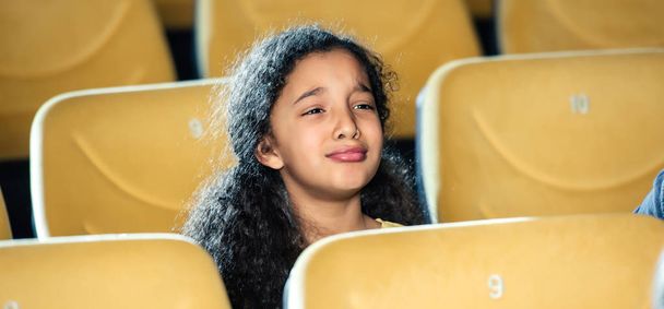 plan panoramique de triste enfant afro-américain regardant un film au cinéma
 - Photo, image