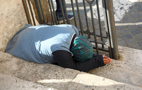 Femme gitane âgée demandant l'aumône agenouillée sur le sol avec
  - Photo, image