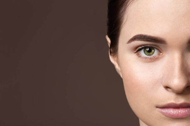 Young woman with beautiful eyebrows on color background, closeup - Fotografie, Obrázek