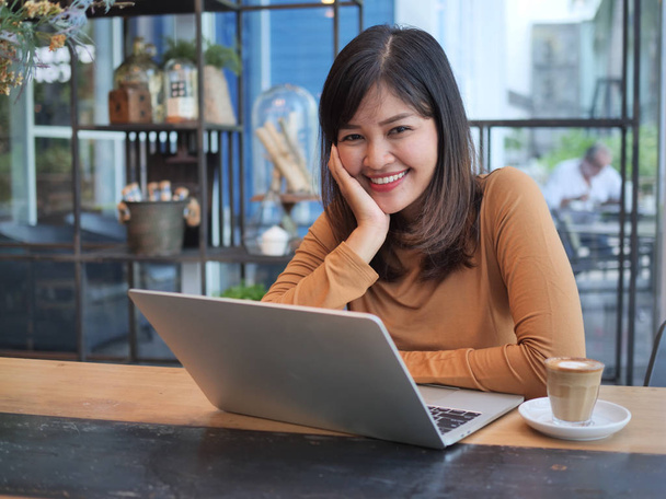 Asian woman using laptop in coffee shop cafe - Valokuva, kuva