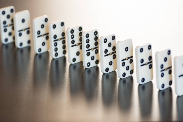 telhas de dominó em uma fileira em um fundo preto
 - Foto, Imagem
