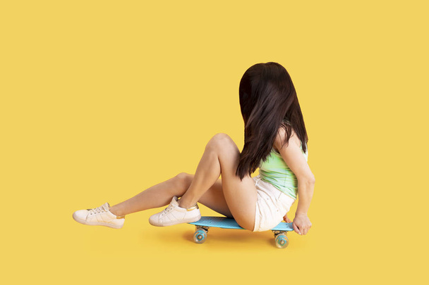 Dziewczyna siedzi na deskorolce - Zdjęcie, obraz