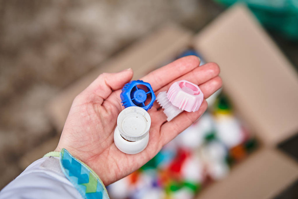 The girl is holding plastic caps for recycling - Photo, image