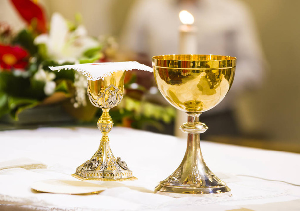 copa con vino y ciborium con anfitrión en el altar de la santa ma
 - Foto, Imagen