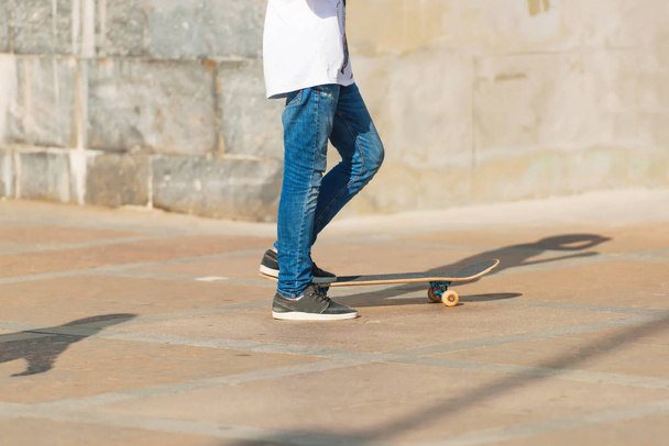 Le type en jean et en skateboard. Le sport extrême. Skateboard en mouvement
. - Photo, image