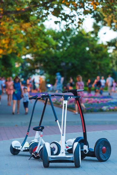 GyroScooter se tient dans le parc. Hoverboards pour monter sur un fond d'arbres verts. Une promenade dans le parc
. - Photo, image
