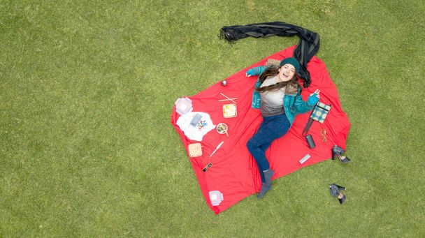 Gorgeous Latina student enjoying a picnic in the park, aerial view, available space for editing, ideal for blogs and ads - Foto, Bild