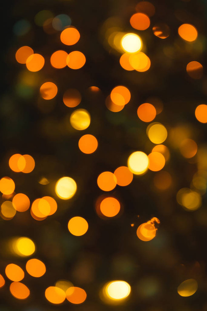 Χριστουγεννιάτικο δέντρο με γιρλάντα και παιχνίδια. Φωτογραφία bokeh. Garland συμπεριλαμβάνονται. Κίτρινο και πορτοκαλί λάμπες φωτός. - Φωτογραφία, εικόνα