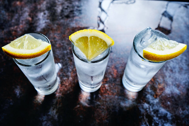 Vodka o gin o tequila in bicchierini sul tavolo di pietra
 - Foto, immagini