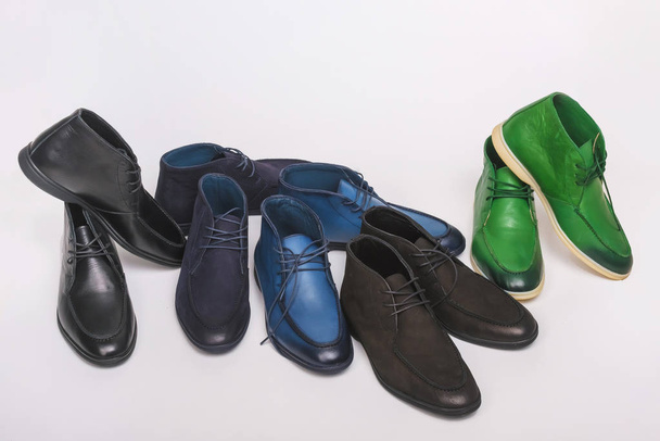 Sapatos masculinos coloridos sobre fundo branco. Sapatos multicoloridos seguidos. Botas elegantes
 - Foto, Imagem