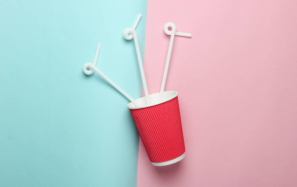 Бумажная чашка кофе с соломинками на цветном пастельном фоне, вид сверху, минимализм
 - Фото, изображение