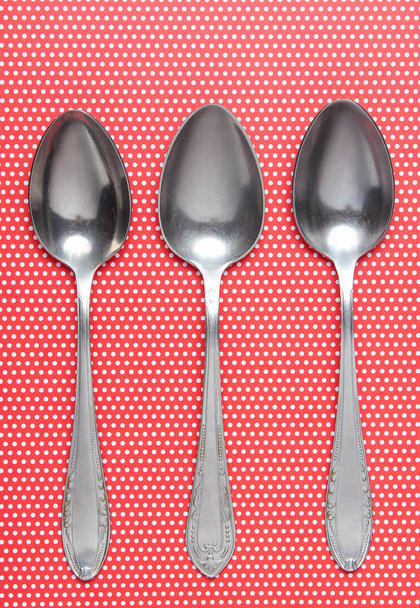 Tres cucharas de metal sobre manteles en lunares. Top vie
 - Foto, Imagen
