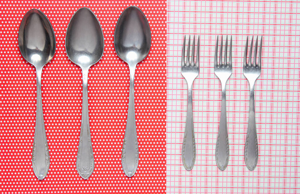 Trois cuillères et fourchettes en métal sur une nappe
 - Photo, image