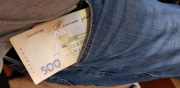 quinientos billetes de dinero ucraniano apilados en un bolsillo de pantalones vaqueros
 - Foto, imagen
