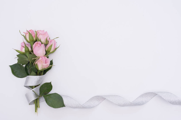 Φωτεινό πολύχρωμο μπουκέτο λουλουδιών σε λευκό φόντο. τριαντάφυλλα δεμένα με κορδέλα - Φωτογραφία, εικόνα