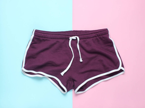 Pantalones cortos de fitness sobre un fondo azul pastel rosado. Vista superior, minimalis
 - Foto, imagen