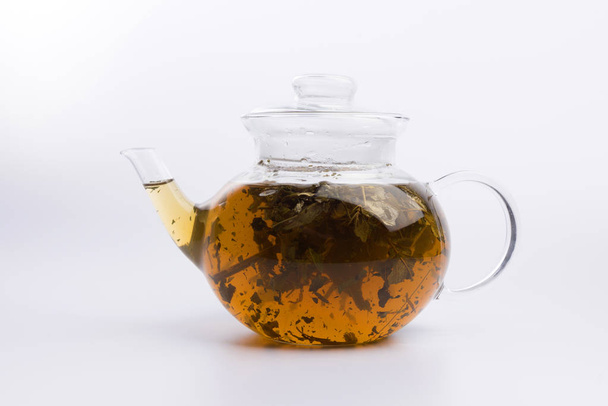 Herbal tea in a teapot with fresh herbs isolated on white background - Foto, immagini
