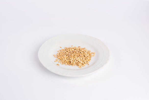 pile of oatmeal on a plate isolated on white background - Foto, immagini