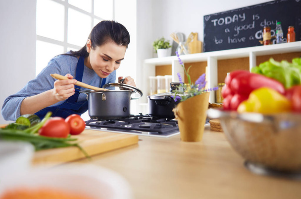 Mujer cocinera en cocina con cuchara de madera - Foto, Imagen
