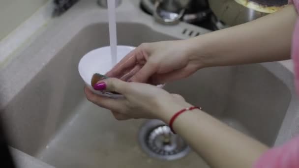 Mujer lavando platos en la cocina. Primer plano de la mano de mujer
 - Imágenes, Vídeo