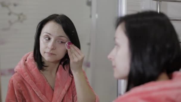 Beautiful brunette woman using cotton pads. Woman removing makeup - Footage, Video