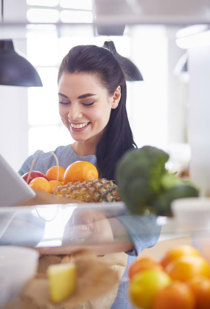 Smiling woman taking a fresh fruit out of the fridge, healthy food concept - Fotografie, Obrázek