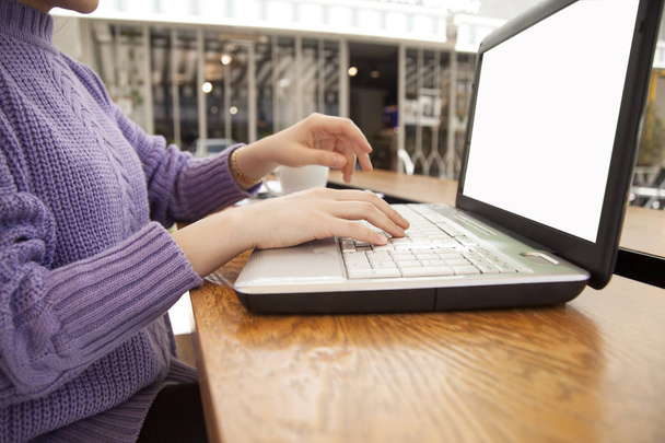 Jonge vrouw werkt met computer in café - Foto, afbeelding