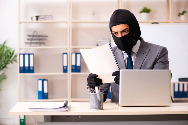 Un gangster masculin vole des informations au bureau - Photo, image