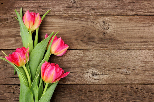 Bouquet de fleurs de tulipes roses sur un fond rustique en bois foncé avec espace de copie
 - Photo, image