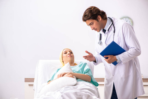 Jonge knappe dokter bezoeken vrouwelijke oncologie patiënt - Foto, afbeelding
