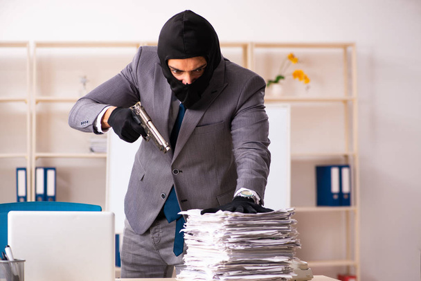 Мужчина-гангстер крадет информацию из офиса
 - Фото, изображение