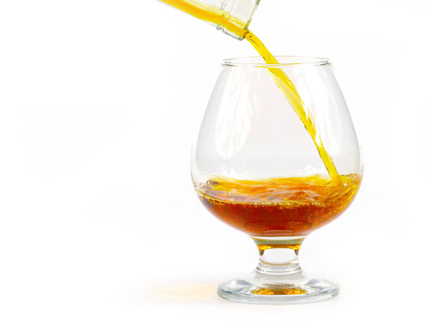strong liquor when pouring into a glass creates elegant bursts - Foto, Bild