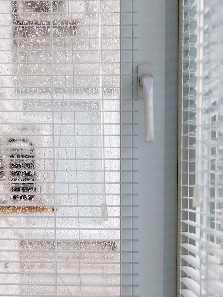 rarainy weather and glass windows with plastic blindsiny weather and glass windows with plastic blinds - Valokuva, kuva