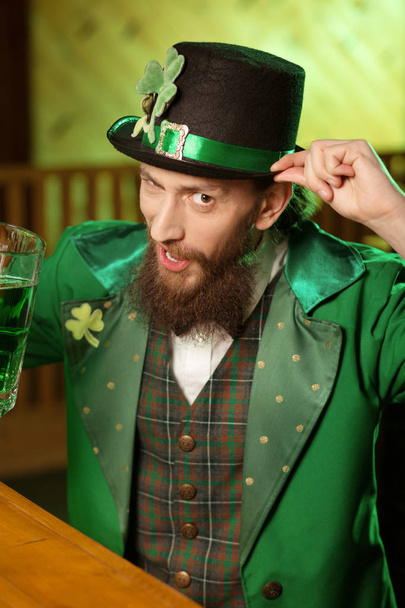 Dark-haired bearded young man in a leprechaun hat feeling great - Fotografie, Obrázek