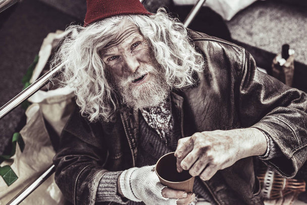 Old mendicant showing strangers where to put money. - Foto, Imagem