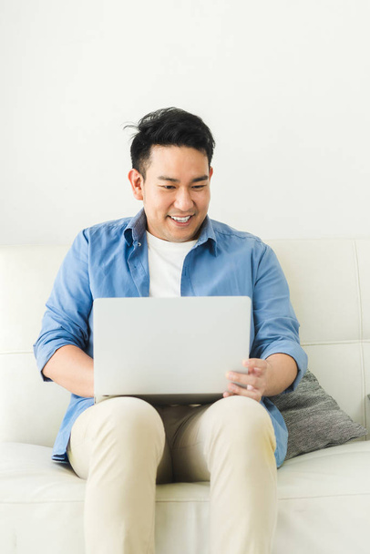 Asian man using laptop at home, lifestyle concept with copy spac - Fotó, kép