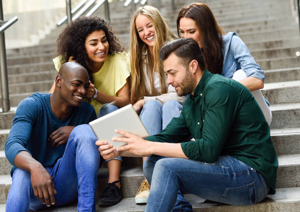 Grupo multiétnico de jóvenes mirando una tableta
 - Foto, imagen
