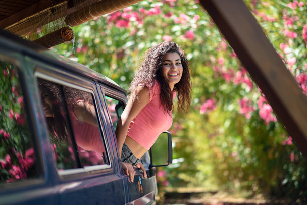 glückliches arabisches Mädchen, das aus dem Fenster eines Lieferwagens blickt - Foto, Bild