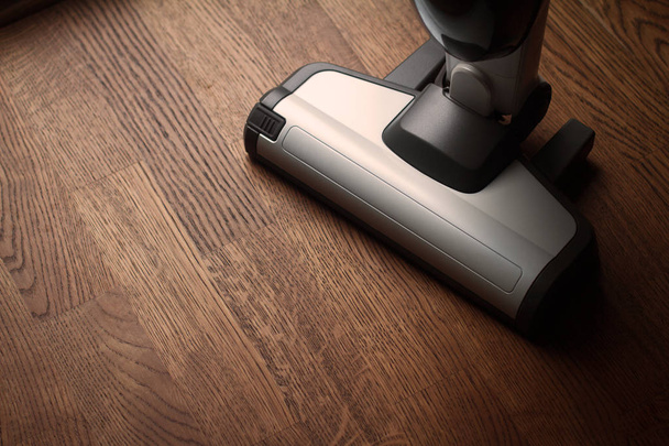 white cordless vacuum cleaner on wooden brown parquet floor - Photo, Image