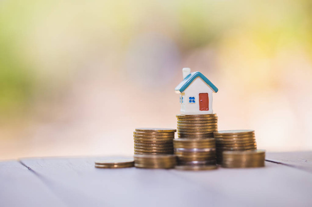 Mini casa na pilha de moedas, dinheiro e casa, hipoteca, poupança
 - Foto, Imagem