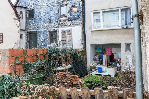 Een vervallen sociale huisvesting in een sociale hotspot met rommel in de tuin, Duitsland - Foto, afbeelding