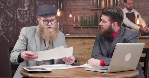 Joven hombre de negocios rubia con barba elegante y su socio de negocios en una reunión
 - Imágenes, Vídeo