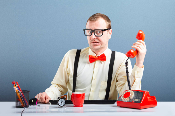 Запутавшийся молодой бизнесмен в очках разговаривает по телефону
 - Фото, изображение