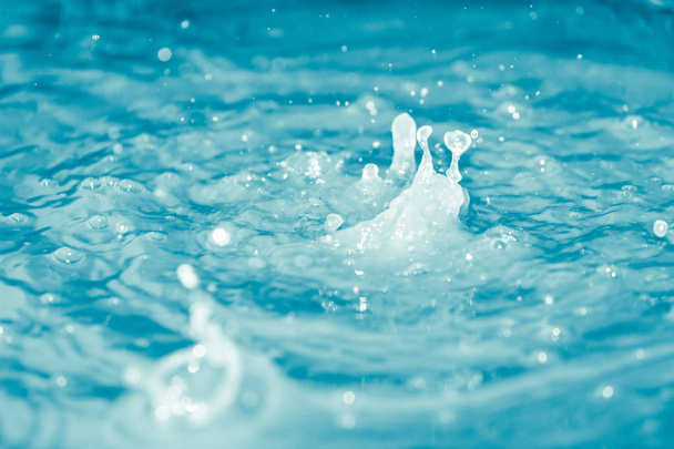 Wassertropfen fallen ins blaue Wasser - Foto, Bild