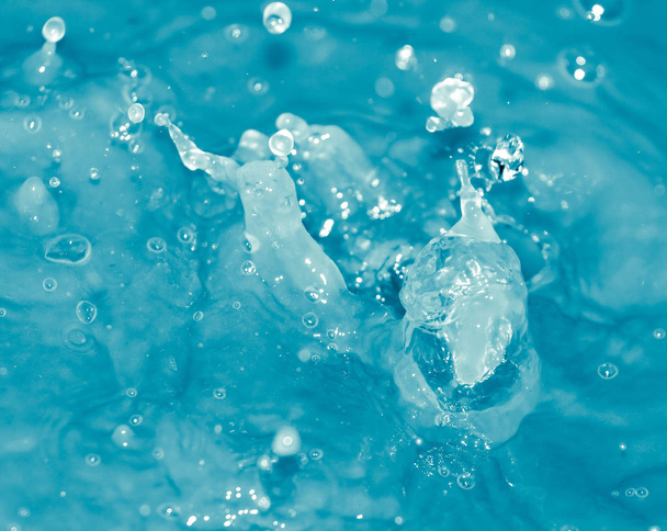 Gotas de agua cayendo en agua azul
 - Foto, imagen