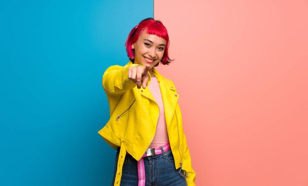 Nuori nainen keltainen takki osoittaa sormella sinua luottavainen ilme
 - Valokuva, kuva