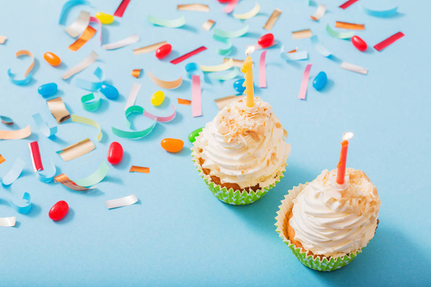 chapéu de aniversário com confete e cupcake no fundo de papel azul
 - Foto, Imagem