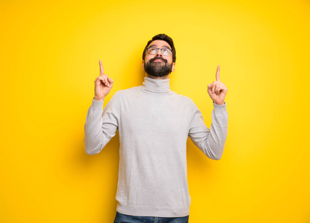 Man with beard and turtleneck pointing with the index finger a great idea - Photo, Image