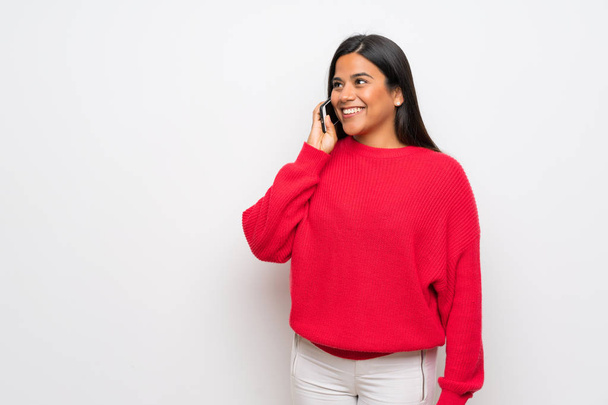 Młoda dziewczyna kolumbijski czerwony sweter prowadzenie rozmowy z telefonu komórkowego - Zdjęcie, obraz