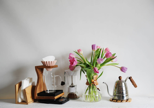 Kytice tulipánů v kávě karafy na bílém stole. Manuál s origami dripper, papírový filtr - Fotografie, Obrázek